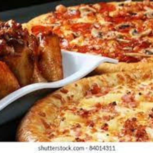 Two pizzas, one pepperoni and mushroom, and one with ham and pineapple, next to chicken wings.